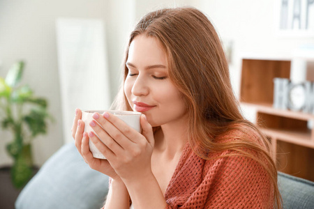 快乐的女人在家里喝茶休息