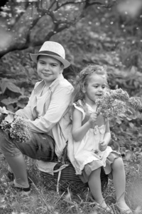 brother and sister walk in the botanical garden in spring 