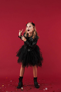 Emotional little girl devil in carnival halloween costume