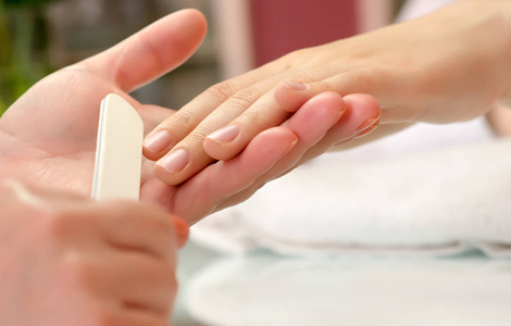 Woman getting nail manicure. 