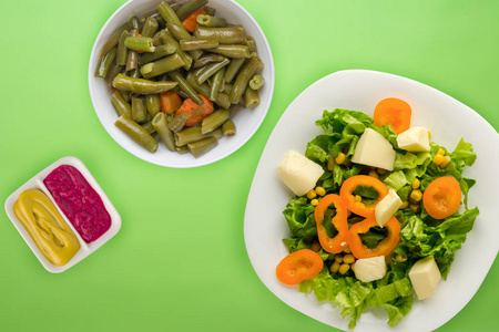  salad of cheese, lettuce, corn, pepper on a colored  background