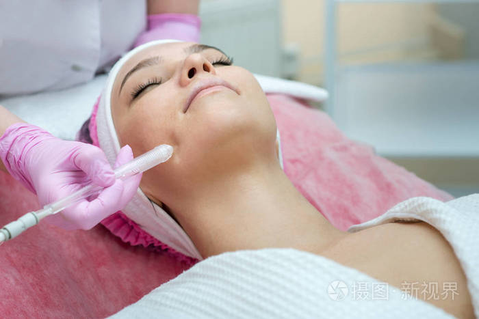 Woman getting face peeling procedure in a beauty SPA salon. 