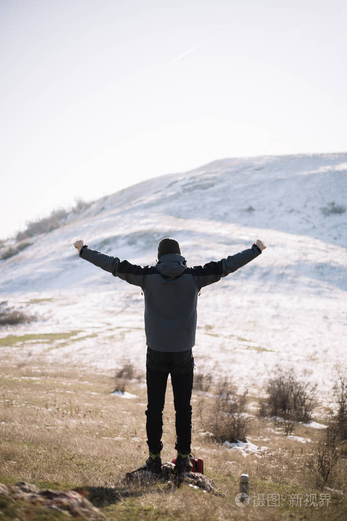 徒步旅行者伸出双手的后视图