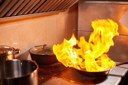 煎锅里着火了.商业厨房烹饪专业厨师.