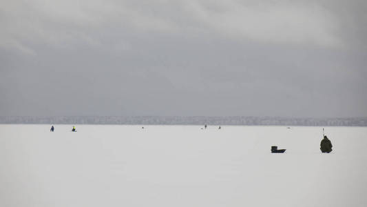 冬季冰上捕鱼，自然背景。渔民在湖边。