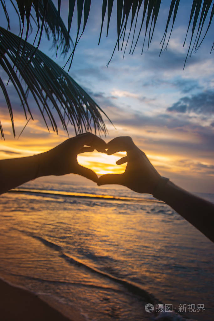 一个女孩和一个男人在夕阳下交了一颗心斯里兰卡选择性聚焦