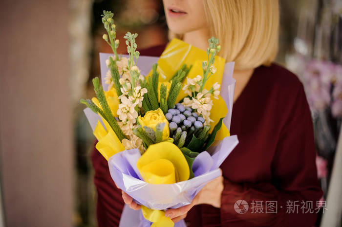 一位手持黄色郁金香花束的女人的特写镜头