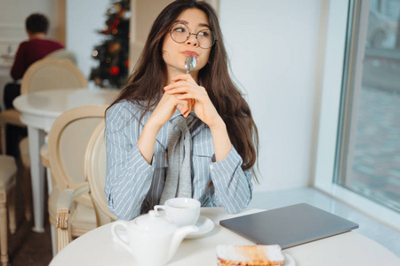 年轻的女人在咖啡馆里悠闲地喝着茶