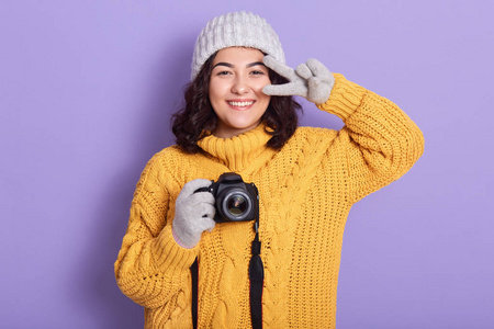 画室背景上单独摆出姿势,显示胜利的迹象,看起来很幸福,表达幸福照片