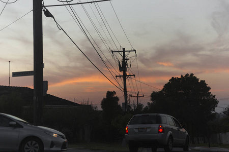 夕阳余晖下，在郊区道路上行驶的汽车