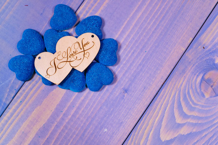 在蓝色背景上用蓝色心形装饰两个木制心形图案,上面刻有"我爱你".