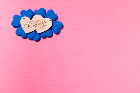 情人节心将两个木制心形装饰成粉红色背景上的蓝色心形i love you字样