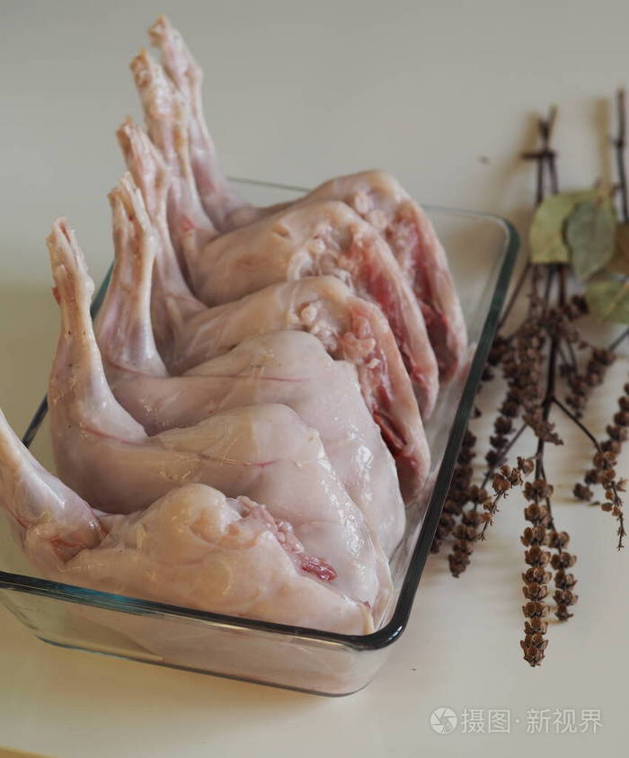 生兔肉的放在玻璃烤盘上。在家做饭，在家做饭。