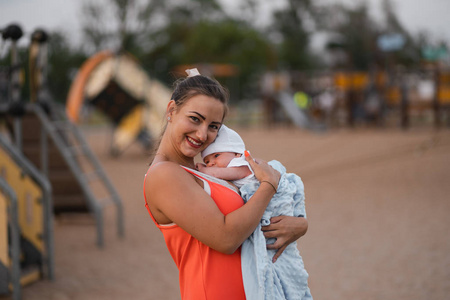 着鲜红的裙子,儿子戴着白色的帽子,家庭价值观暖色夏日场景手持式照片