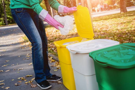 志愿者女孩在公园的街道上分类垃圾。回收的概念。零浪费理念。自然