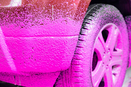 汽车服务部提供洗车服务，用粉色泡沫清洗带有樱桃味的污垢
