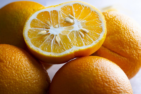 减少趋势半个丑陋的双层有机橘子,有种子,形状奇特,周围有许多水果.