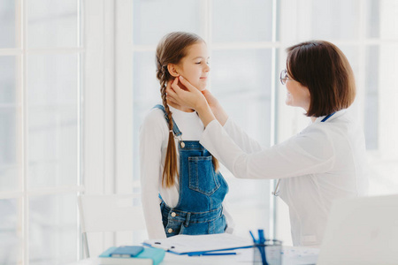 女儿科医生检查儿童咽喉，是专业的儿科医生，咨询孩子如何预防扁桃体炎，给予良好的治疗和护理。体检概念。