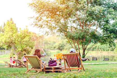 坐落在草地的椅子上一对幸福的夫妇在暑假坐在花园的椅子上,在公园里