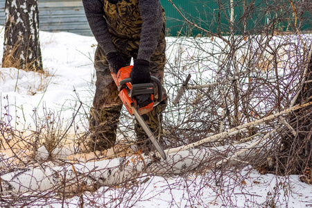 一个伐木工人在冬天用电锯锯锯树的特写镜头。2020年1月18日，俄罗斯车里雅宾斯克