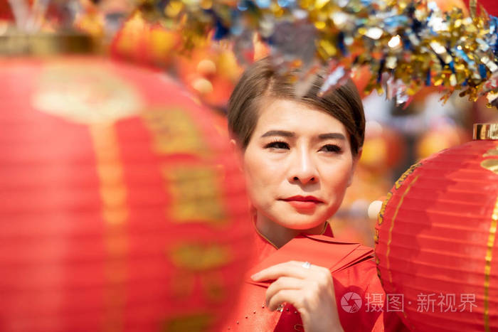 一位亚洲妇女正拿着红包过年。
