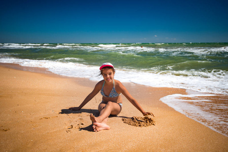 快乐美丽的小女孩在沙滩上休息