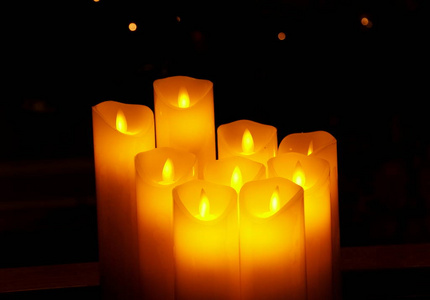 一束在黑暗中有火焰的黄色蜡烛