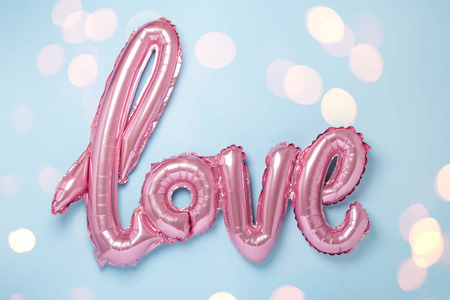 蓝色背景上的粉红色气球，单词Love。情人节庆祝。博克效应