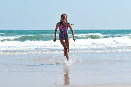 在海滩上奔跑的少女。海上快乐的孩子