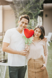 Asian couple in love holding heart shape flower. Vanlentine day 