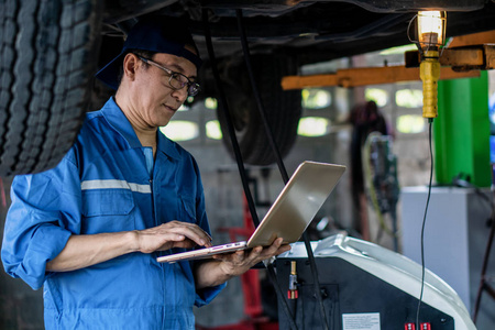 portrait of asian male car mechanic performing car checking and 