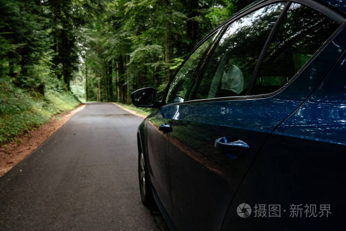 路上有森林环绕的汽车