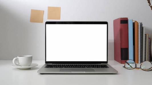 Cropped shot of workspace with blank screen laptop, books, eye g