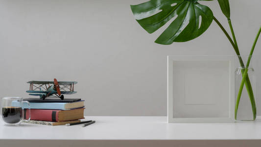 Close up view of workspace with copy space, books, mock up frame