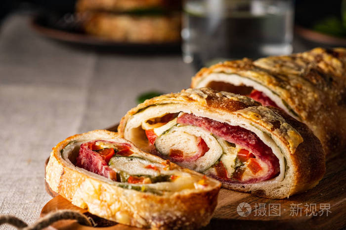 传统的意大利斯特朗博利奶酪，意大利香肠，红辣椒和菠菜。深色风格的照片。
