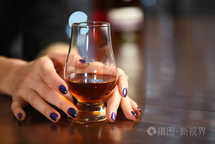 女人手拿着一杯威士忌