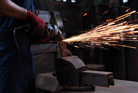 机械工程师在黑金属车间用热火花操作角磨机刀具工业工人的手在生产工厂炼铁