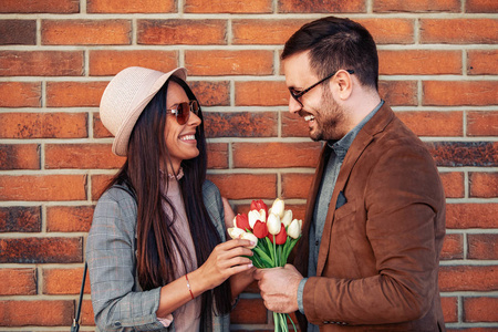 Romantic man giving flowers to his girlfriend 