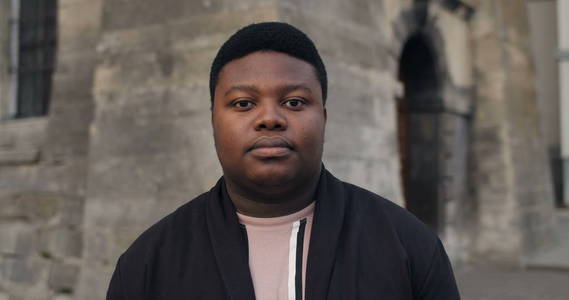 表情的高清背景站在老城街上的自信男人的正面图.