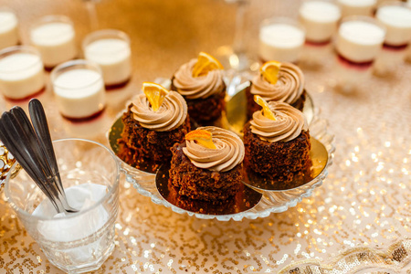 为婚宴准备糖果和糖果的桌子，装饰好的甜点桌。糖果自助餐上的美味糖果。宴会的甜点桌。蛋糕，纸杯蛋糕。