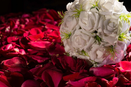 在红玫瑰花瓣的衬托下，有一束白玫瑰。