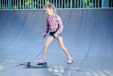 十几岁的女孩练习滑板，户外滑板公园