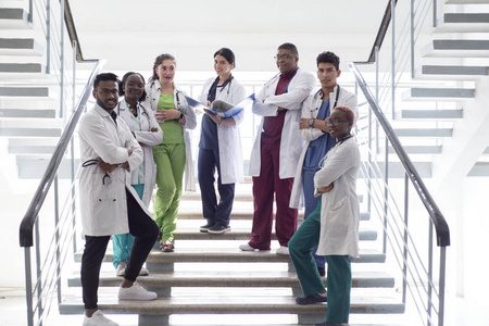 混血儿，一群年轻的医生，学生。穿着白大褂的男女，戴着电话内视镜，微笑着，在医院走廊的台阶上摆姿势