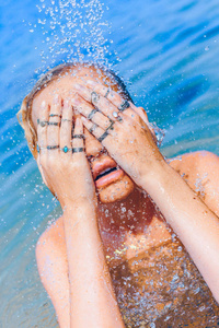 beautiful young woman in splash of water close up 