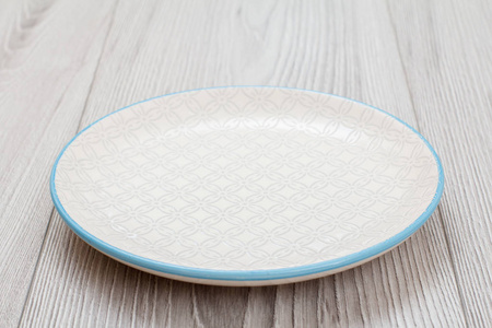 Empty ceramic plate on gray wooden background