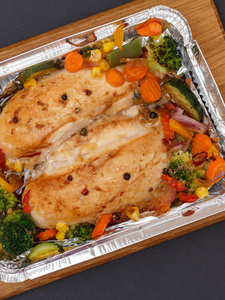 在金属容器里烤鸡胸或里脊肉和蔬菜。