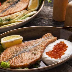 Salmon steak with cream and red caviar. 