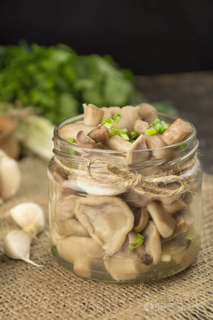 在玻璃罐里腌蘑菇蘑菇配香草和香料家里的食物腌菜素食侧视图特写复制
