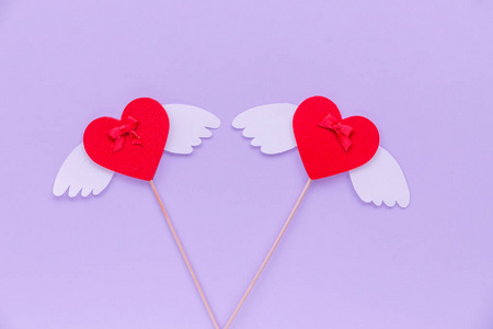 紫色背景上有翅膀的两颗心两颗银色的心形图案,背景是银色的.