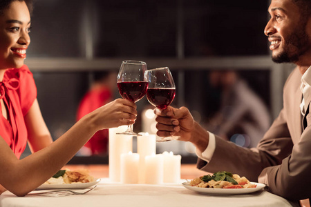 非裔美国人的配偶在餐厅碰杯浪漫约会